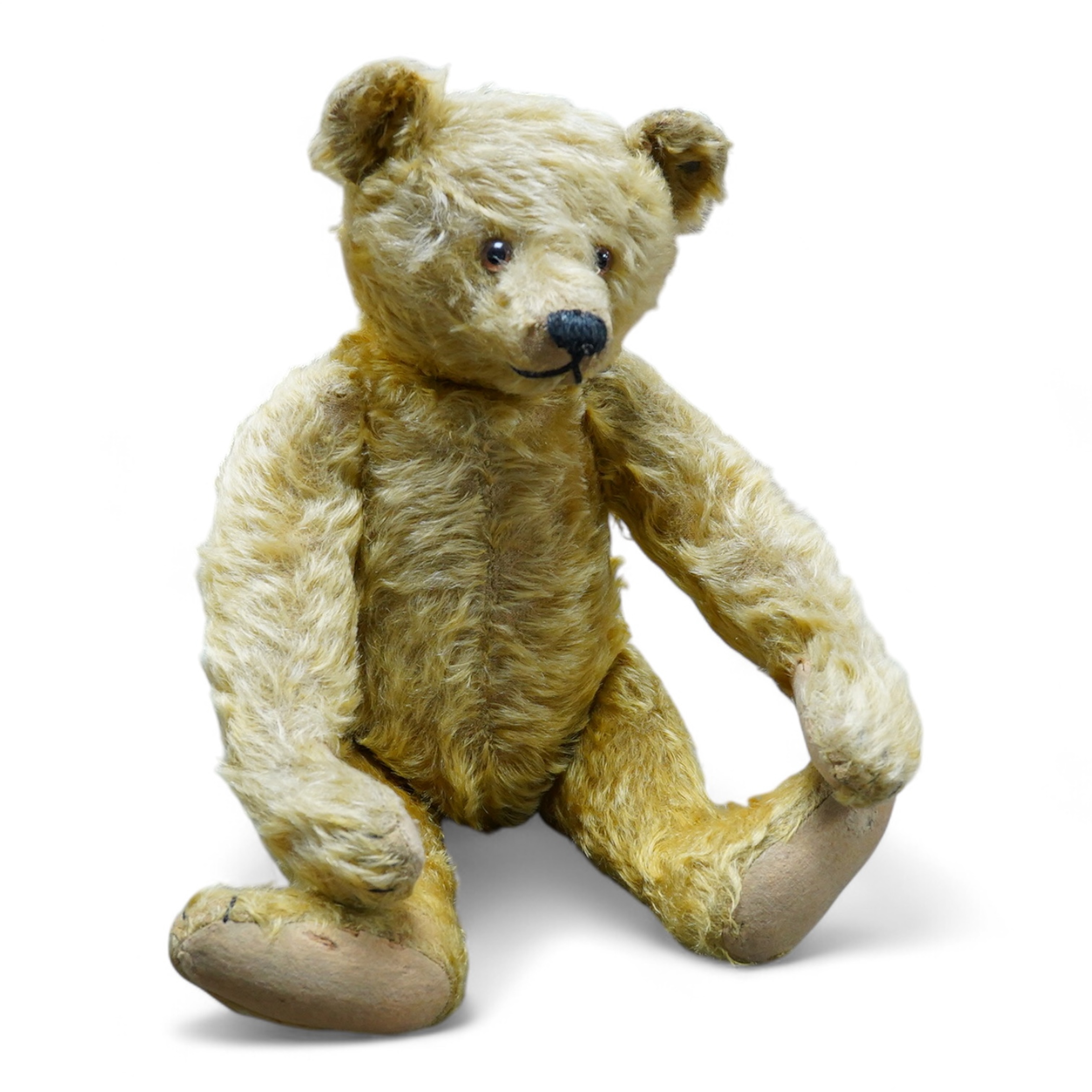 A Steiff cinnamon plush Teddy bear, stitched snout and glass eyes, jointed limbs, button in ear, circa 1910, 43cm